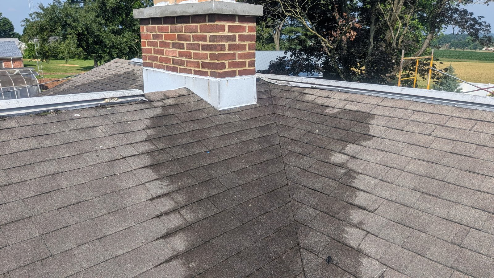 After: rebuilt brick chimney with new concrete crown on roof in York PA by LBE Masonry