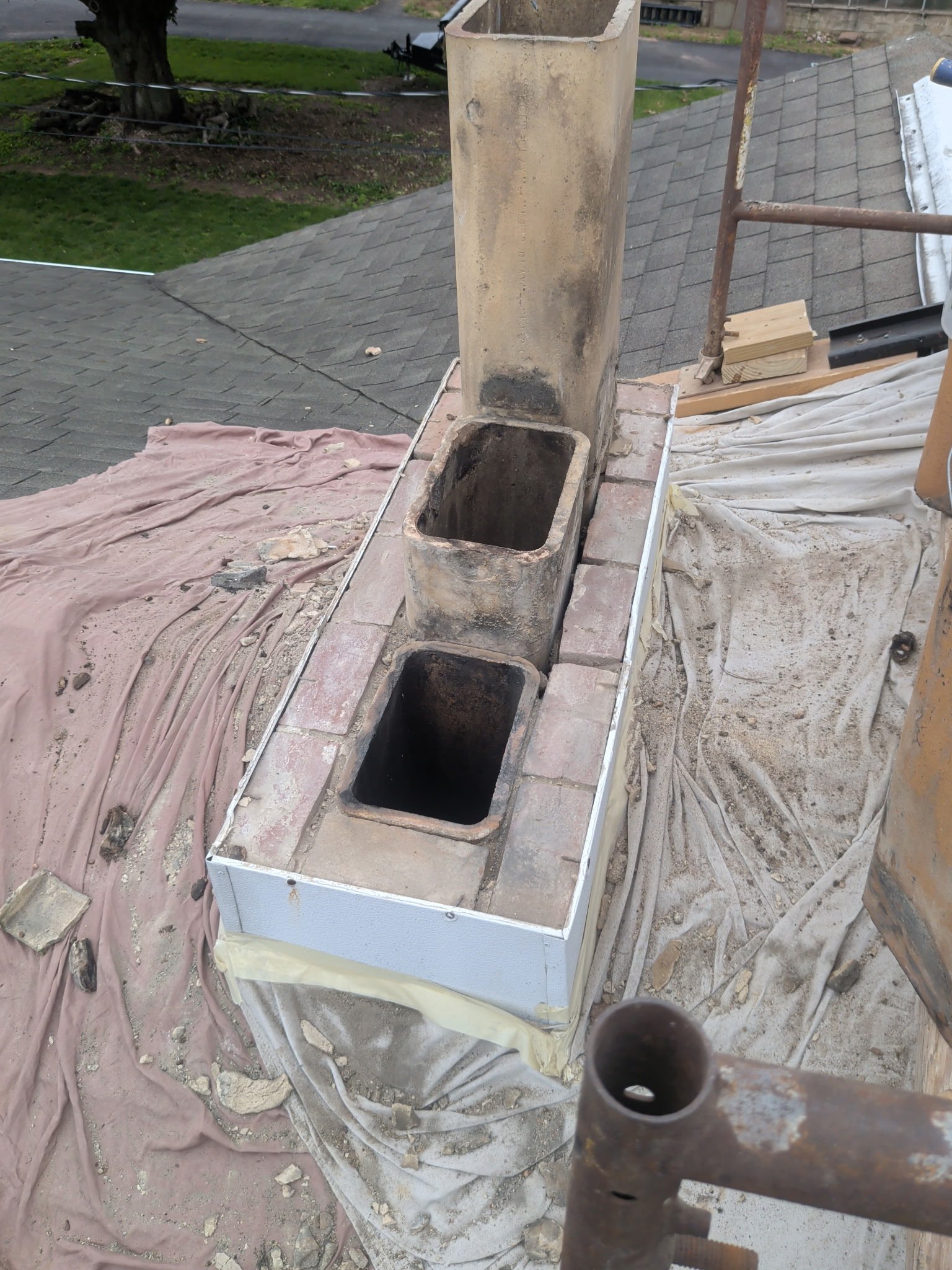Close up of deteriorated chimney base and flashing condition before LBE Masonry rebuild in York PA