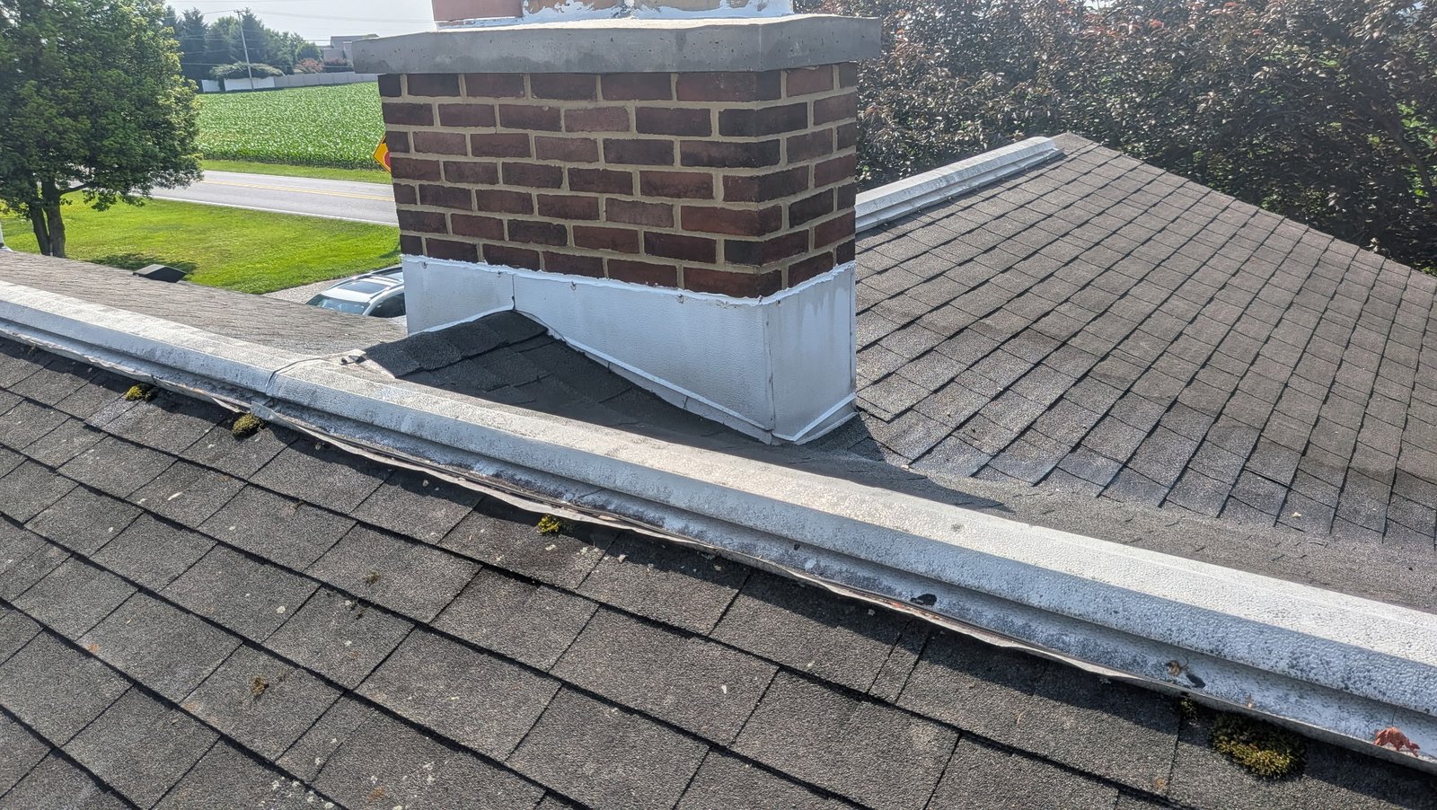 Brick chimney rebuilt back up to roofline with three flue liner extensions visible during construction in York PA by LBE Masonry