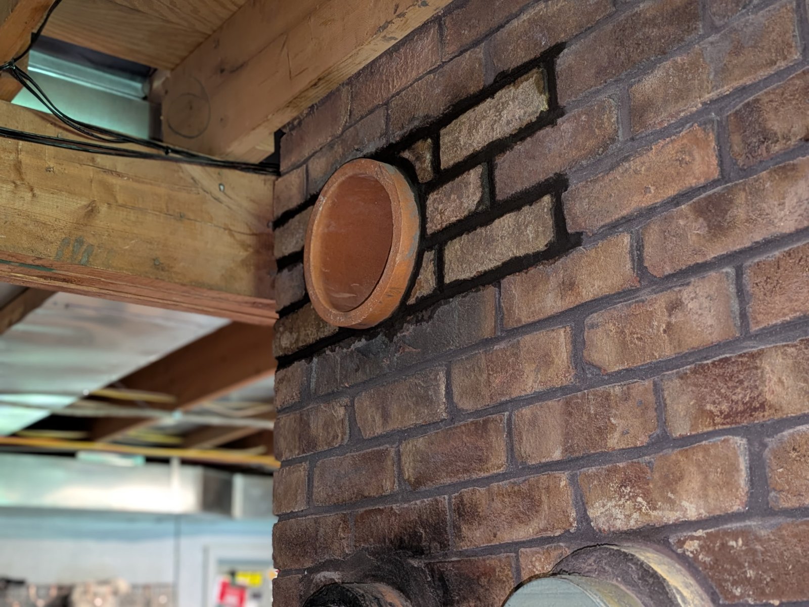After: new terracotta flue liner installed with rebuilt brick infill blending into existing wall pattern by LBE Masonry