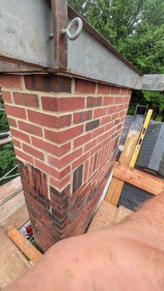 Close view of the rebuilt chimney top with new red brick, a soldier course and basket-weave band, and the precast concrete crown being set, York County PA