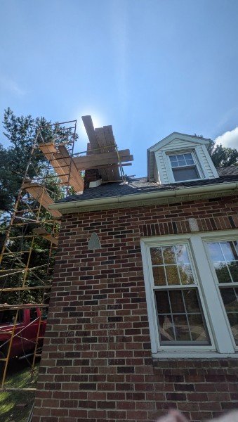 Scaffolding set up along the side of a brick house to reach the chimney for a top rebuild, York County PA